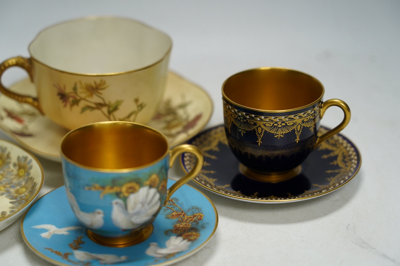 Four miniature Worcester cups and saucers, including a blush ivory ground, one signed G Johnson, largest 12.5cm wide. Condition - fair